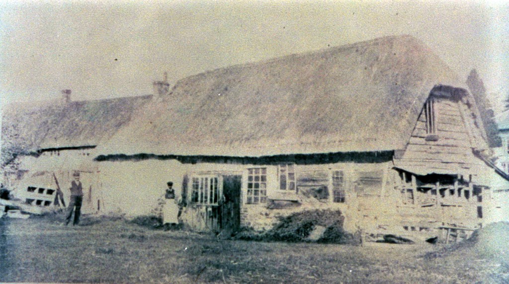 The Chair Workshop, a thatched building, two works standing outside